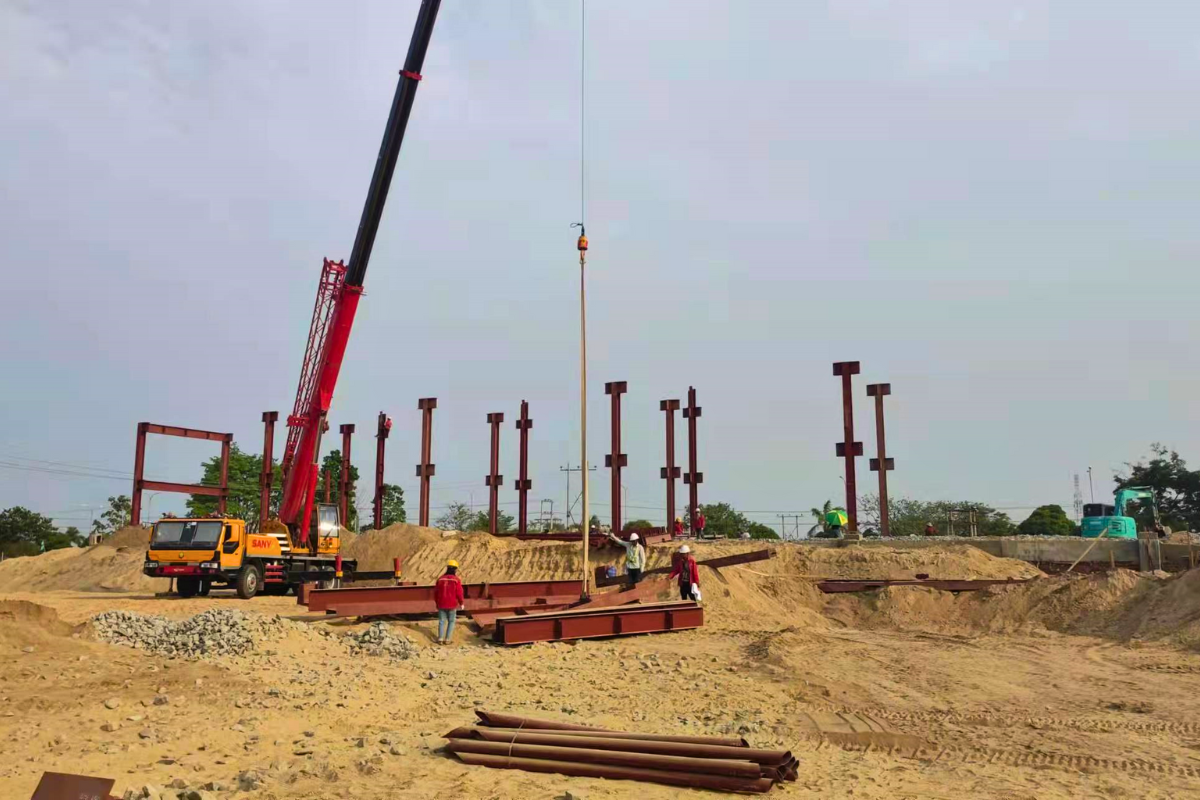 Panoramic view of steel structure erection at the Emerald E-Commerce Center construction site in Naypyidaw, Myanmar, with a crane lifting components