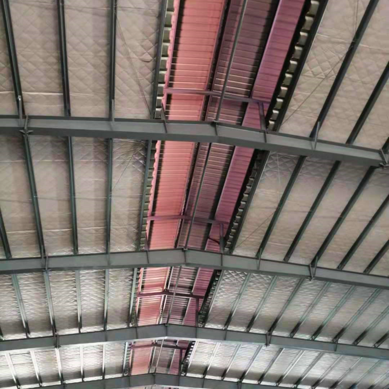 Interior view of the installed roof insulation and ridge ventilation/skylight system by Myanmar Yi Jin at a steel structure warehouse project site in Yangon, Myanmar.