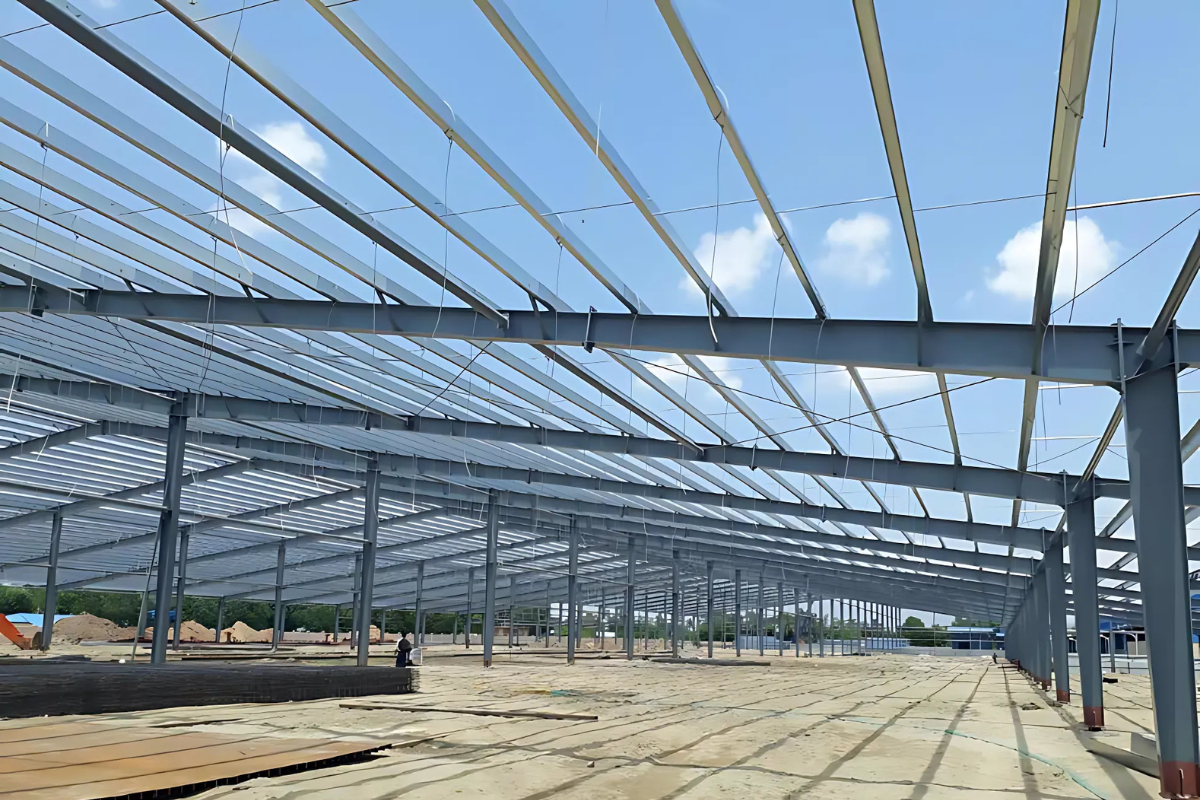 A wide interior view of the 23,696 sq.m Myanmar Knitting Factory in Pathein, highlighting the extensive steel structure frame and the RC foundation.