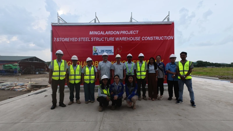 Sae Paing Development Co. Ltd construction project team standing in front of Mingalardon 2-story steel warehouse banner