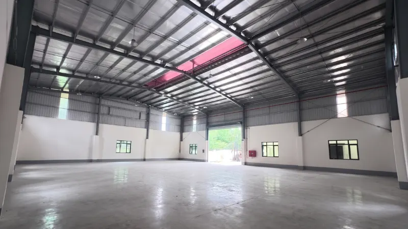 Wide interior span showing structural steel roof trusses and finished floor for Lwai Ngin Lwai Kham warehouse