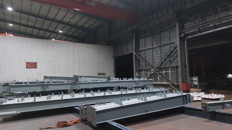 Precision-fabricated structural steel beams lined up inside the Myanmar Yi Jin production workshop for the Aung Kan Bo project.