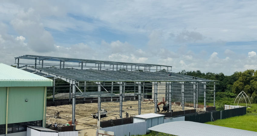 Structural steel framing and column installation for the 60m x 36m Performance Auto International factory extension in Yangon
