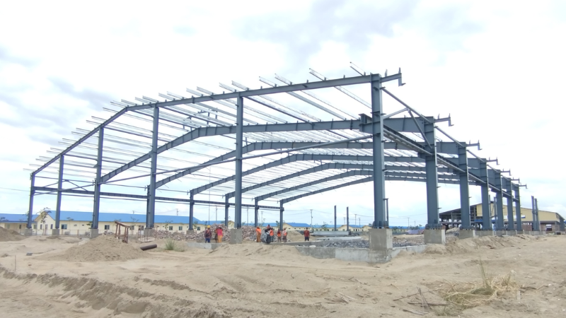 On-going steel structure framing and roof truss erection for Mandalay Business City Development 45.72m x 91.44m warehouse project by Myanmar Yi Jin.